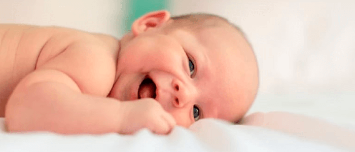 Bebê deitado e dando risada - Plano de Saúde para Recém-Nascido