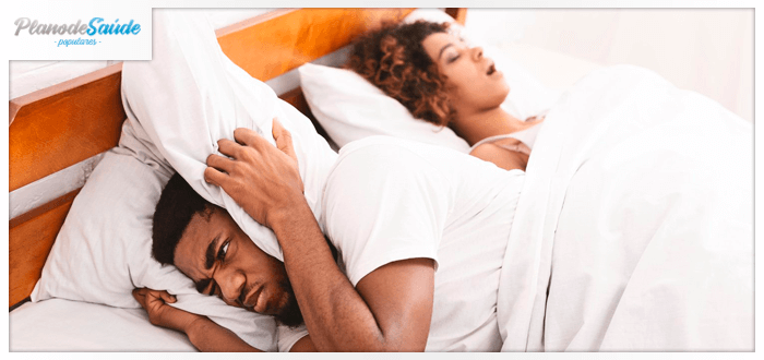 Homem tentando bloquear o som do ronco da esposa - apneia do sono