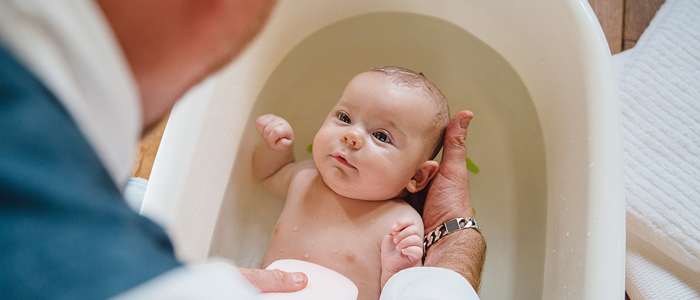 Homem dando banho em recém-nascido - cólica em bebê
